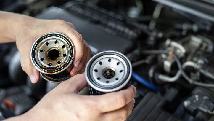 A do-It-yourselfer is swapping out an old oil filter for a brand-new FRAM filter.