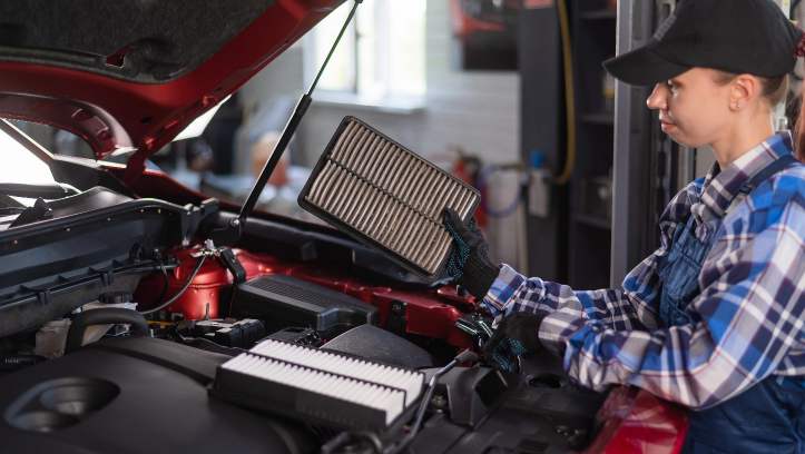 A DIY enthusiast replaces an old engine air filter with a new FRAM Air Filter in her garage.